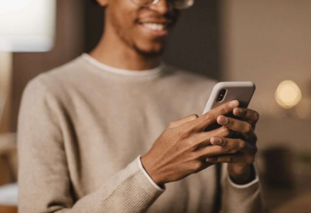 Homem sorrindo ganhando dinheiro pelo celular
