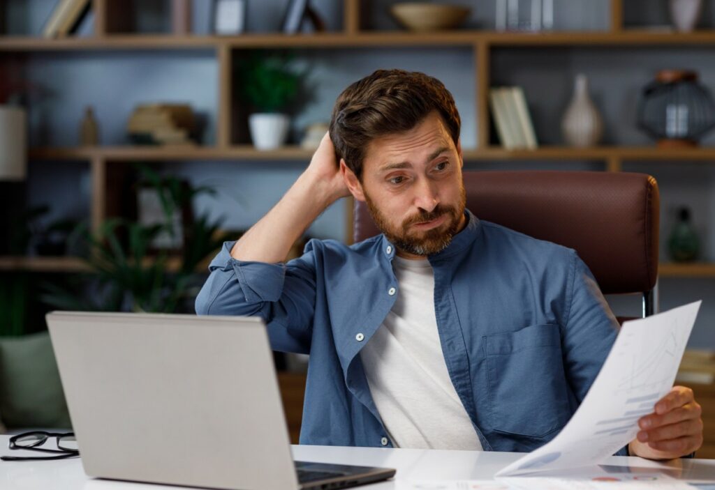 Homem com barba com a mão atras da cabeça com o rosto preocupado entendendo como abrir um MEI