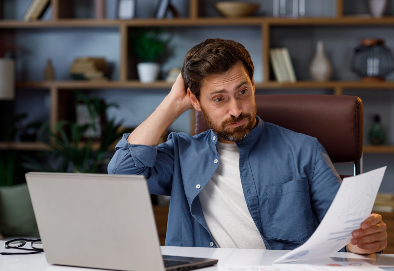Homem com barba com a mão atras da cabeça com o rosto preocupado entendendo como abrir um MEI