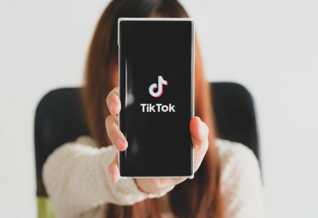 mulher mostrando o celular com o TikTok na tela
