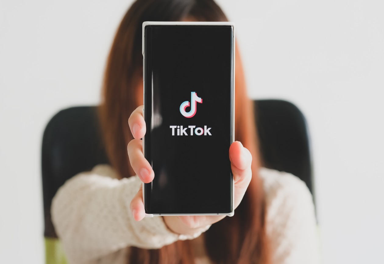 mulher mostrando o celular com o TikTok na tela